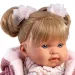 Llorens: Păpușa plângătoare Alexandra de 42 cm cu suzetă, îmbrăcată într-o jachetă roz tricotată și fustă cu flori.